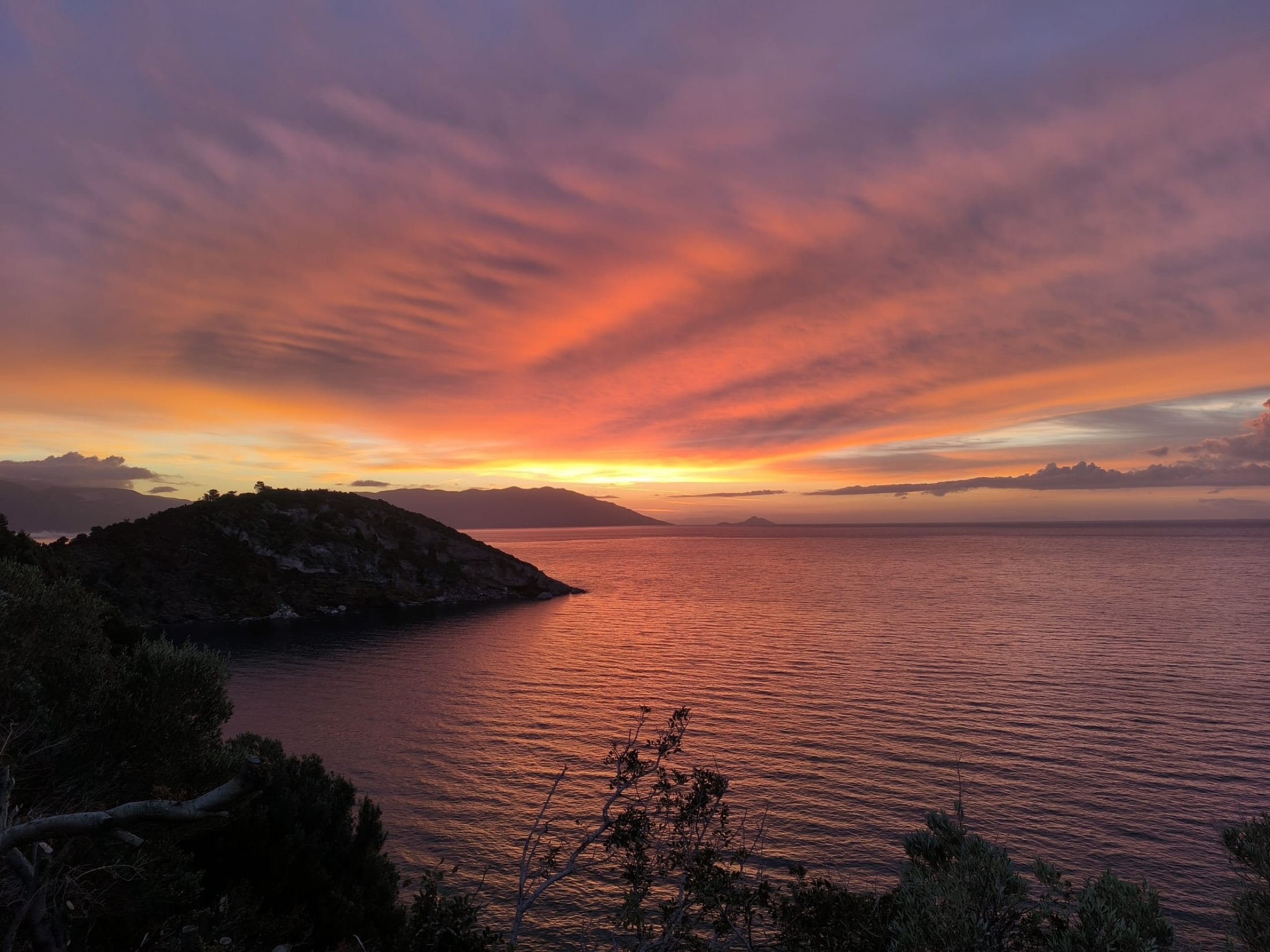 A vivid sunset over a quiet bay, photographed by Myrte