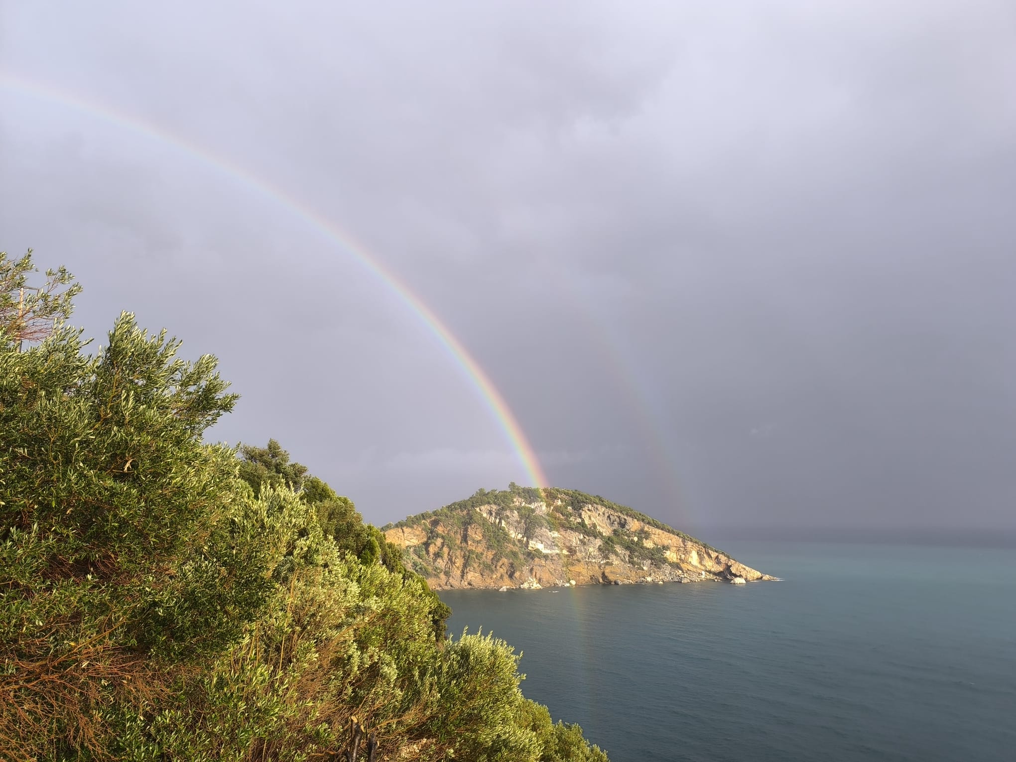 A rainbow over an island and the sea, photographed by Myrte